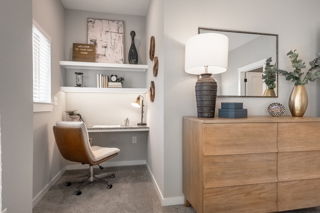 A room with a chair, a desk, and a mirror.