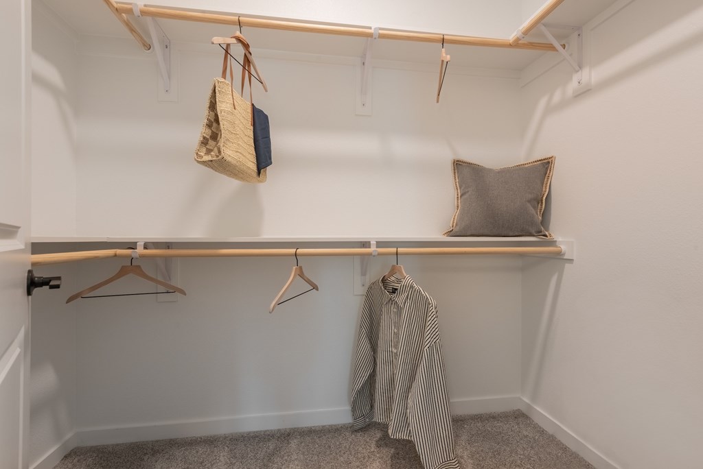 A closet with a striped shirt hanging on a hanger.