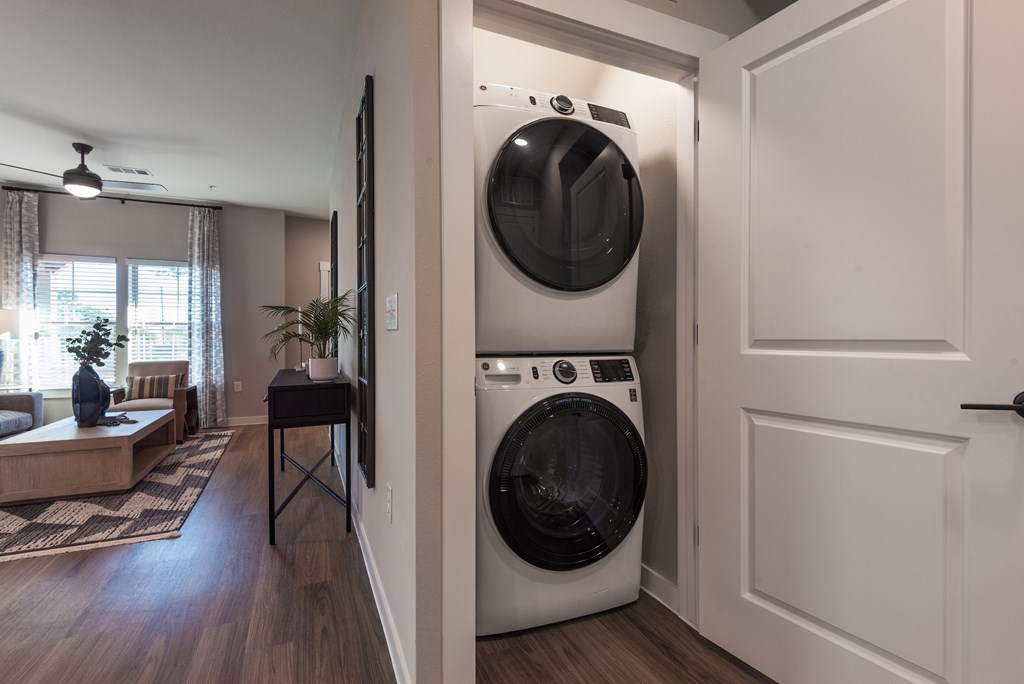 A white washing machine is in a small laundry room.