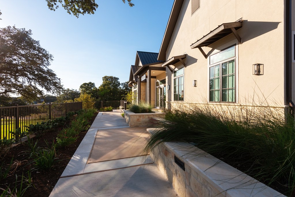 A long, narrow walkway leads to a building with a stone wall on one side.