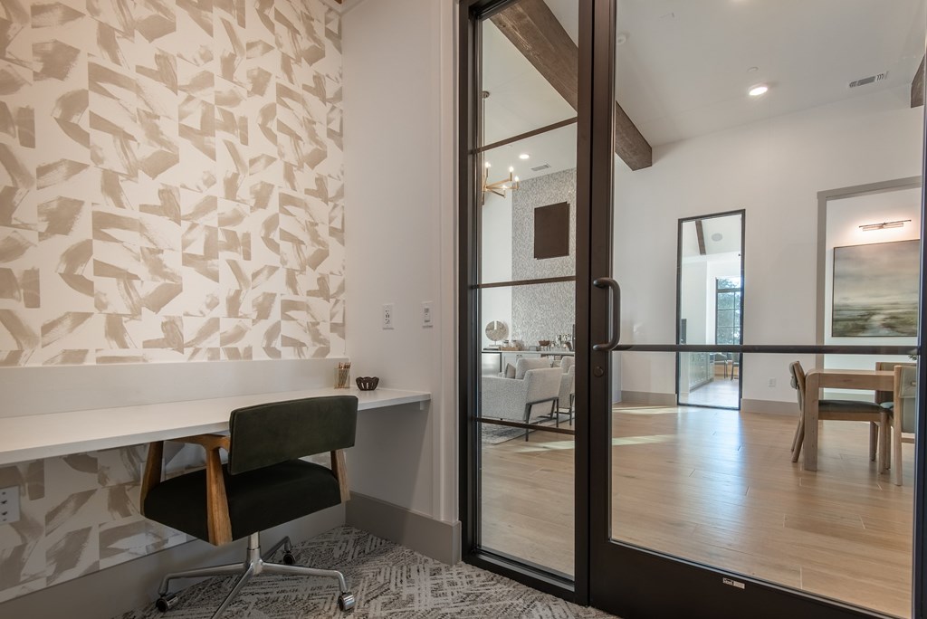 A room with a white desk and a black chair.