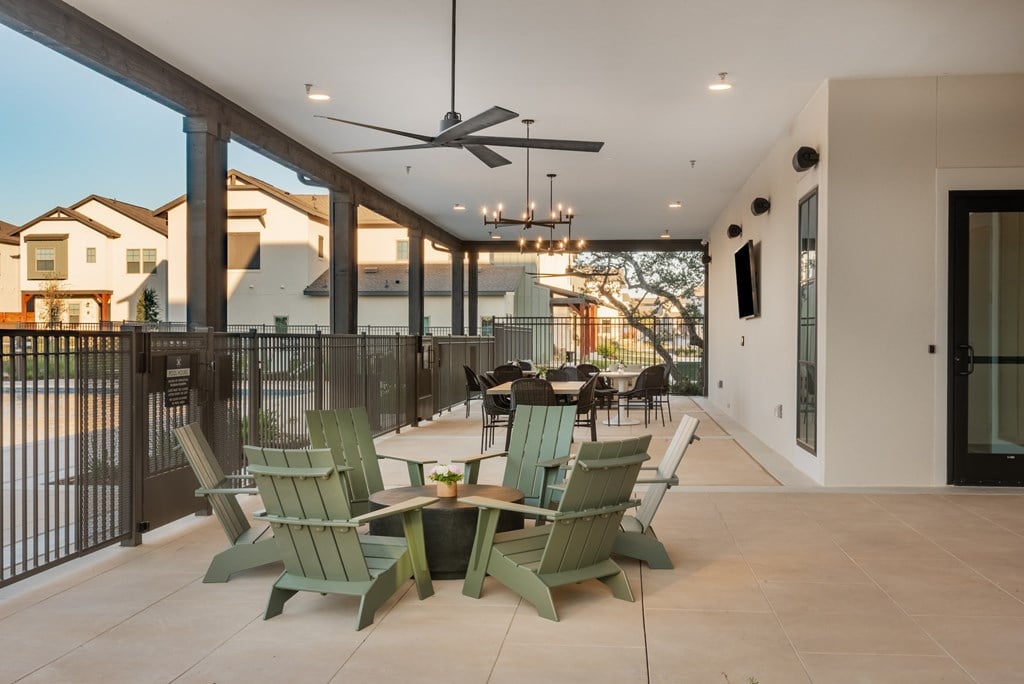 A patio with green chairs and a table is set up.