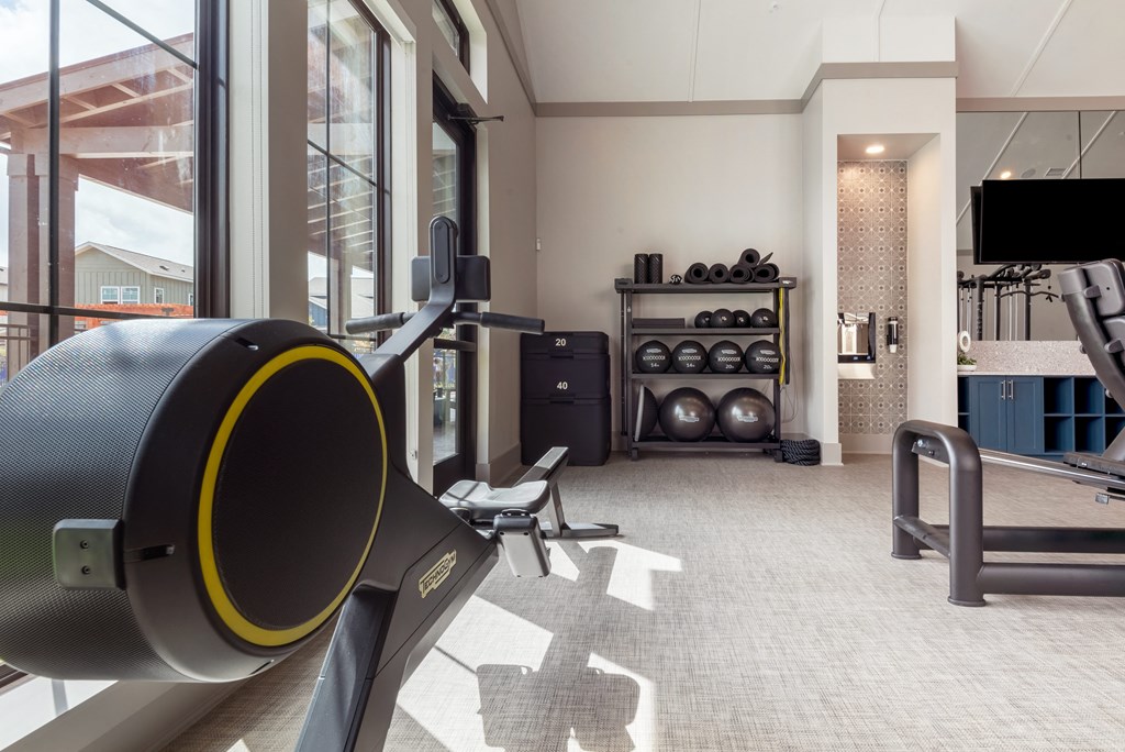 a gym with exercise equipment and a large window