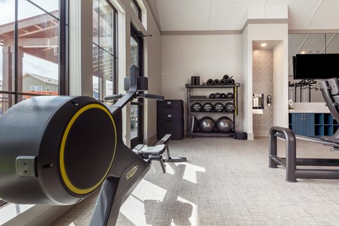 a gym with exercise equipment and a large window