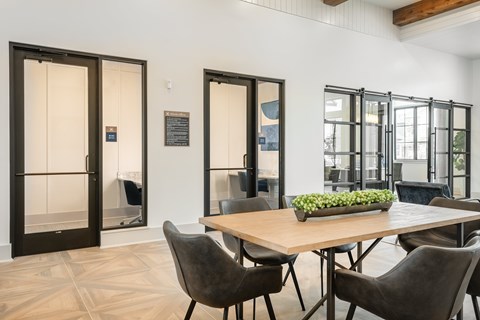 A dining room with a table and chairs and a glass door.