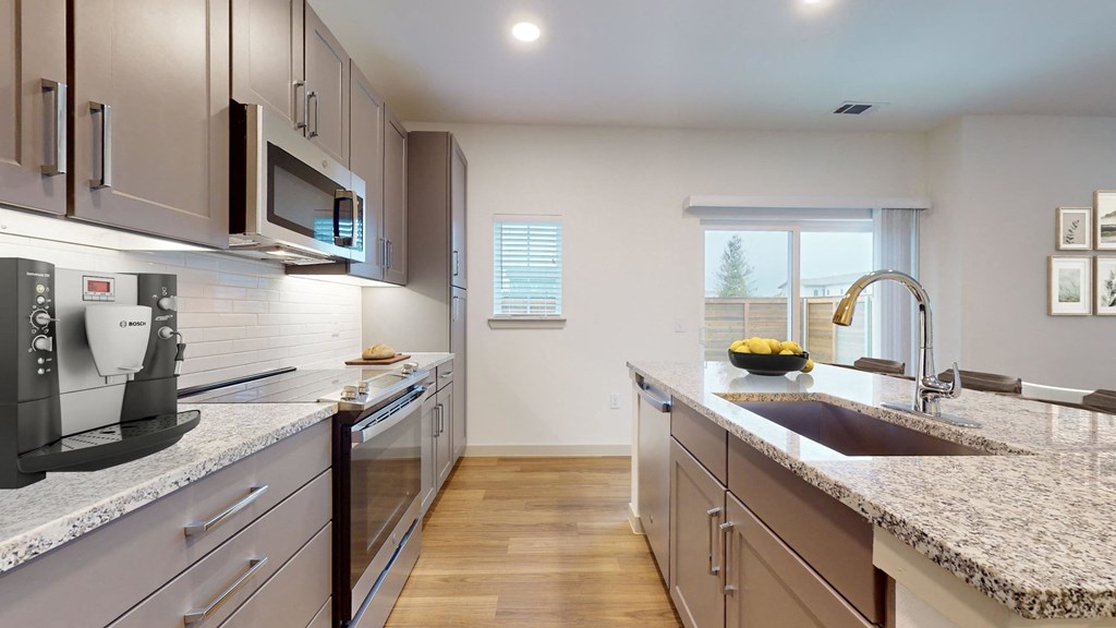 a modern kitchen with granite counter tops and stainless steel appliances