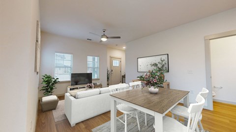 a living room and dining room with white furniture and a table