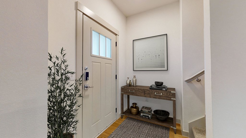 the entrance to a bathroom with a white door and a plant