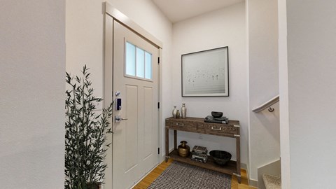 the entrance to a bathroom with a white door and a plant