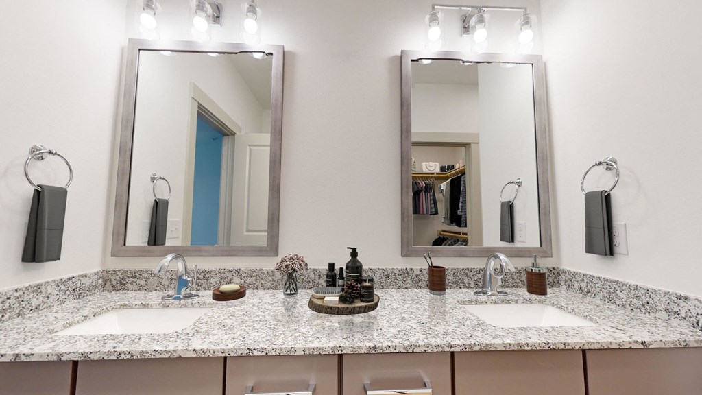 a bathroom with two sinks and two mirrors