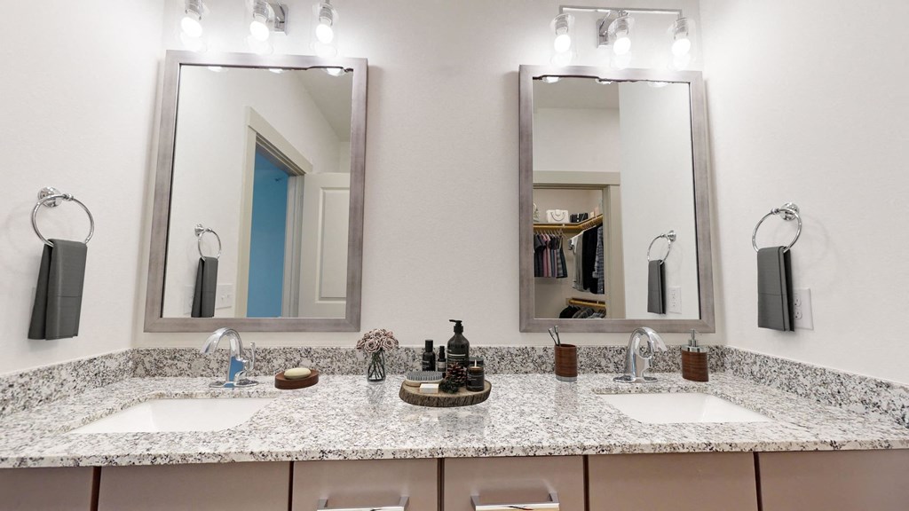a bathroom with two sinks and two mirrors