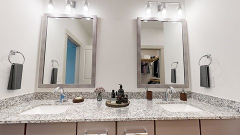a bathroom with two sinks and two mirrors
