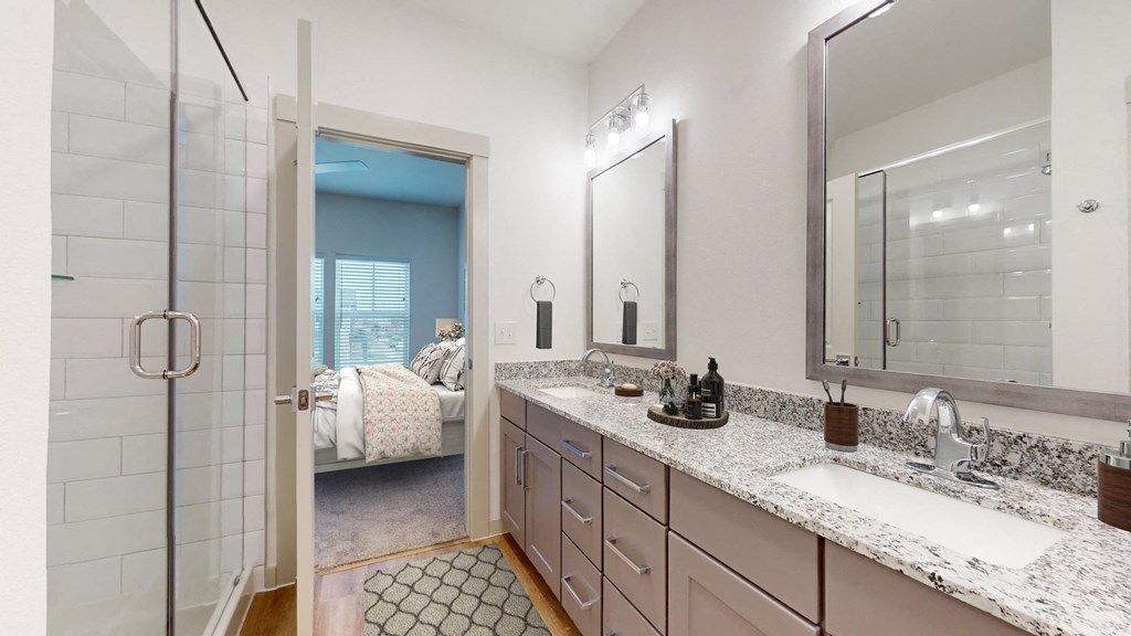 a bathroom with a sink and a shower and a mirror