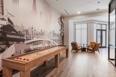 A room with a pool table and a wall mural of a bridge.