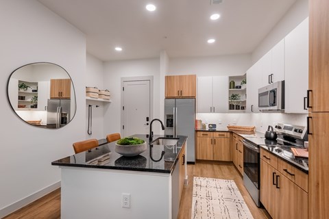 A modern kitchen with wooden cabinets and a black countertop.