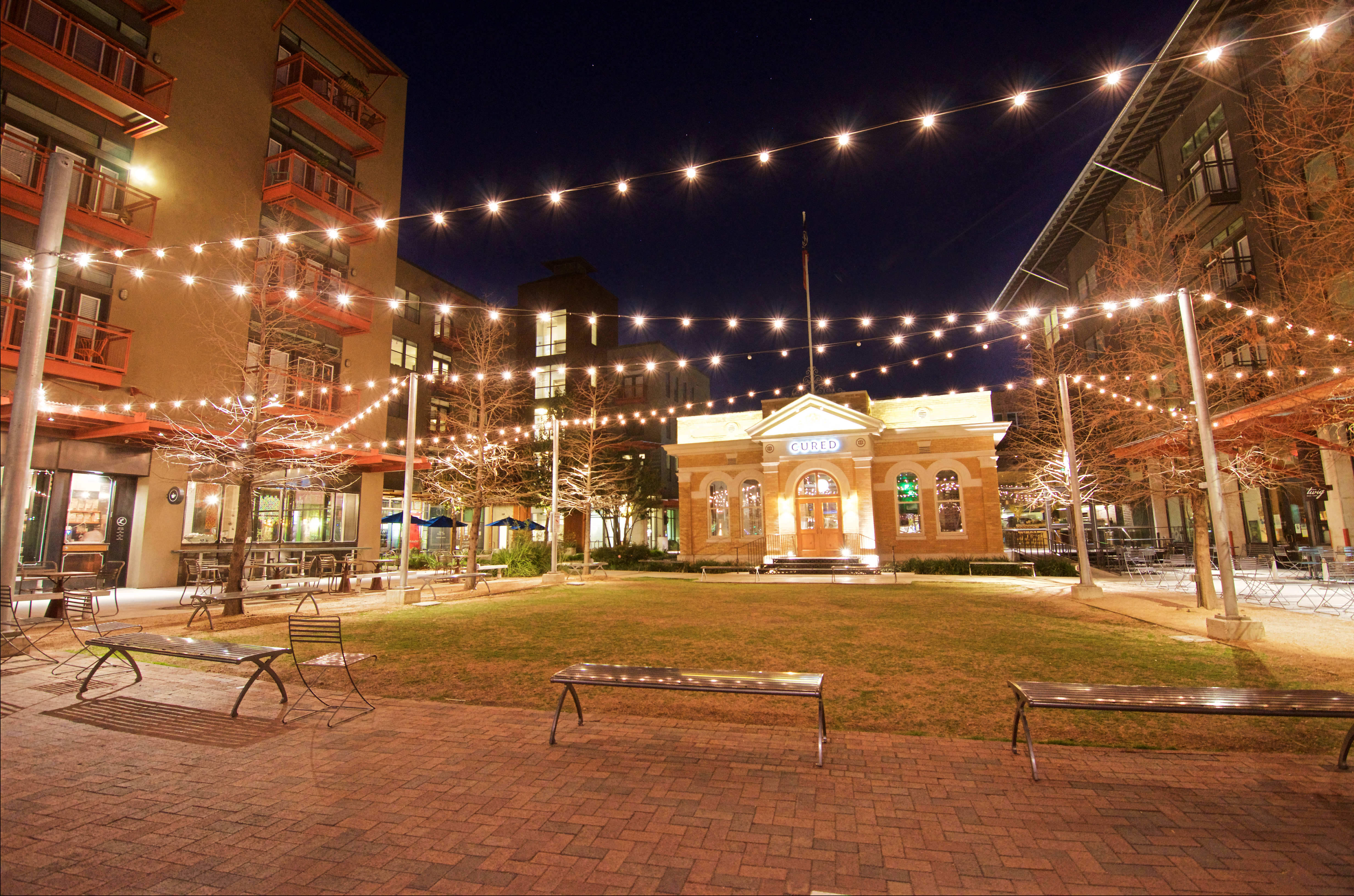 Evening View of Pearl Parkito Located in Front of Cured at The Can Plant Residences at Pearl, San Antonio, Texas