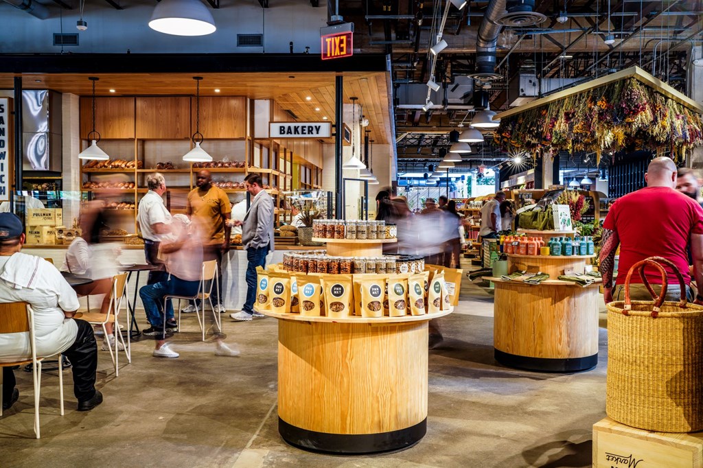 a crowd of people standing around a bar in a restaurant
