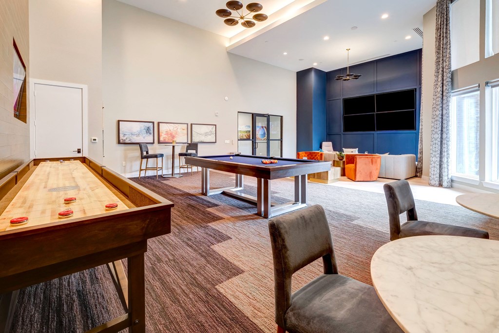 a game room with a pool table and a large screen tv