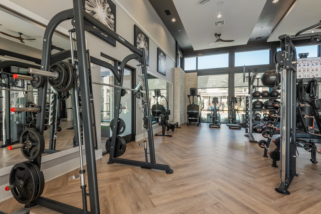 a gym with weights and other exercise equipment on a wooden floor