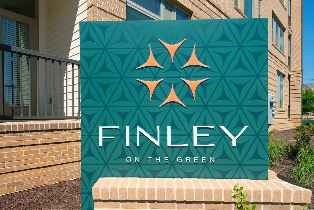 A sign that says "Finley on the Green" is displayed in front of a building.