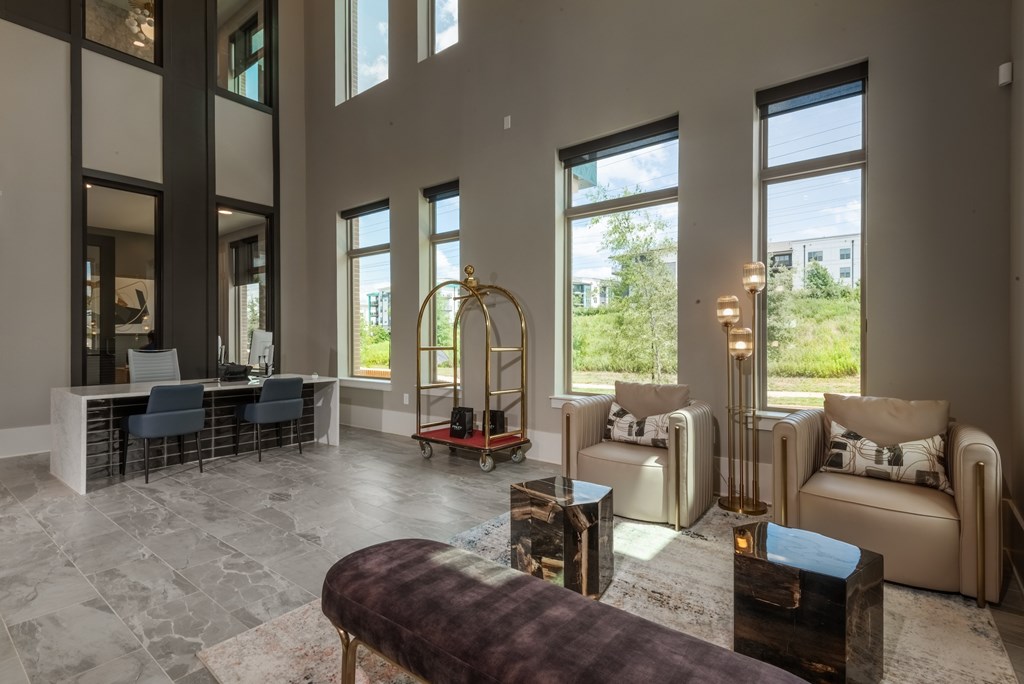 A living room with a large window and a view of greenery outside.