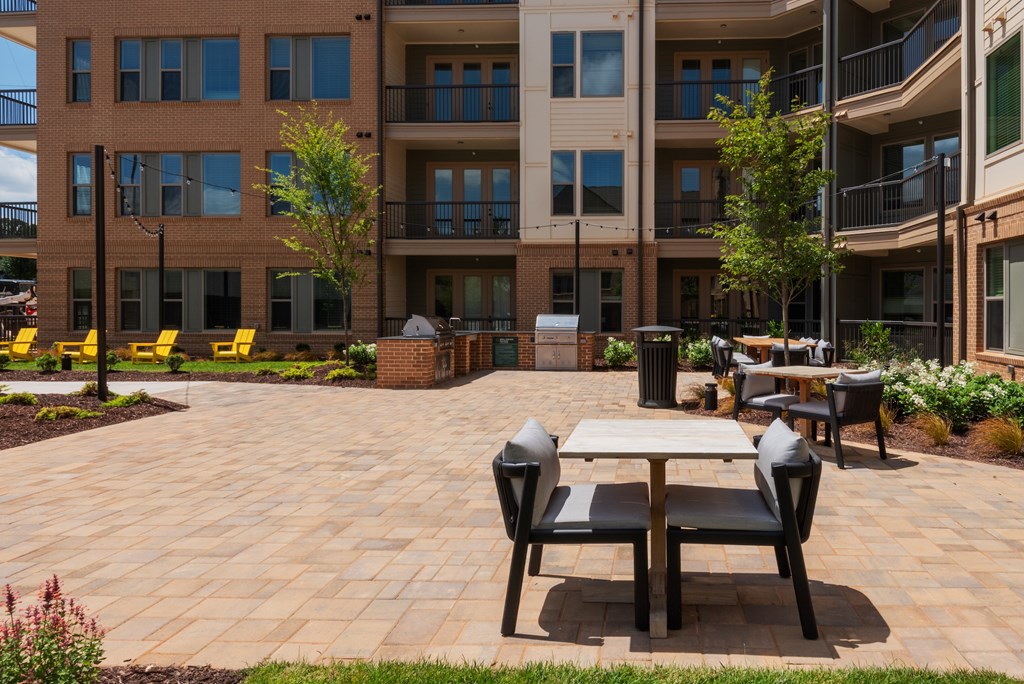 A patio with a table and chairs in front of a building.