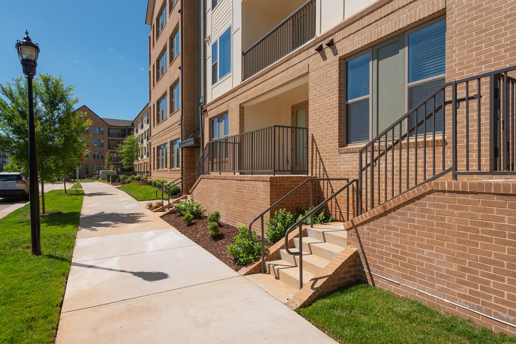 A building with a brick wall and a black railing.