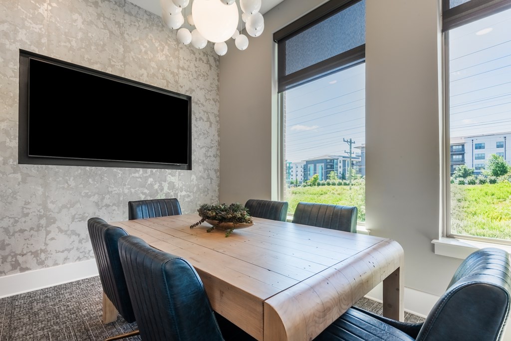 A conference room with a large table and chairs.