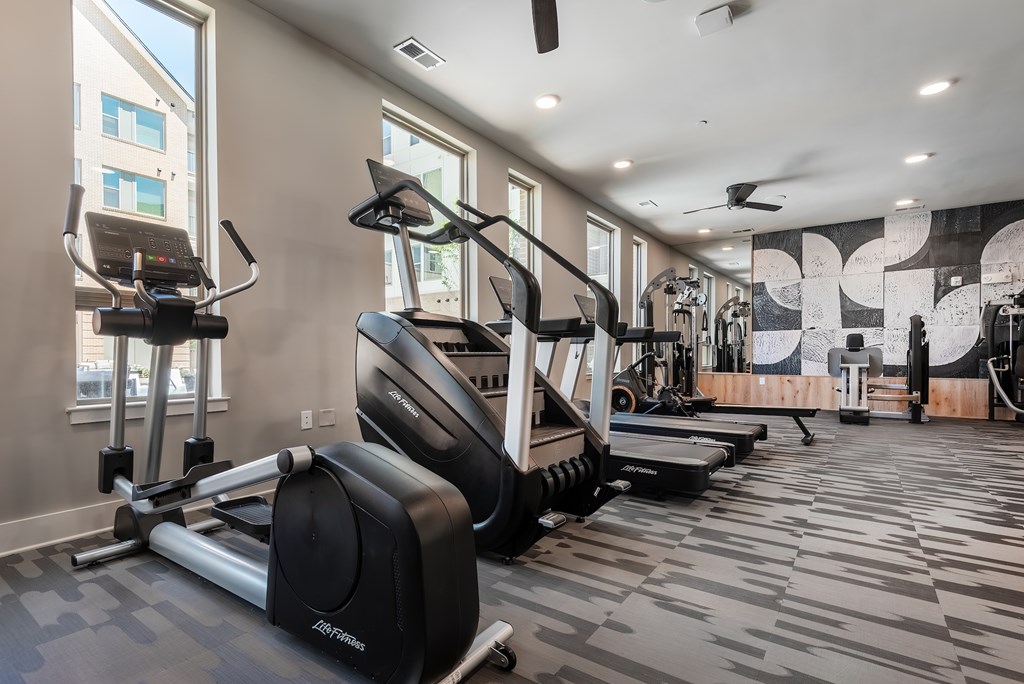 A gym with treadmills, elliptical machines, and other exercise equipment.