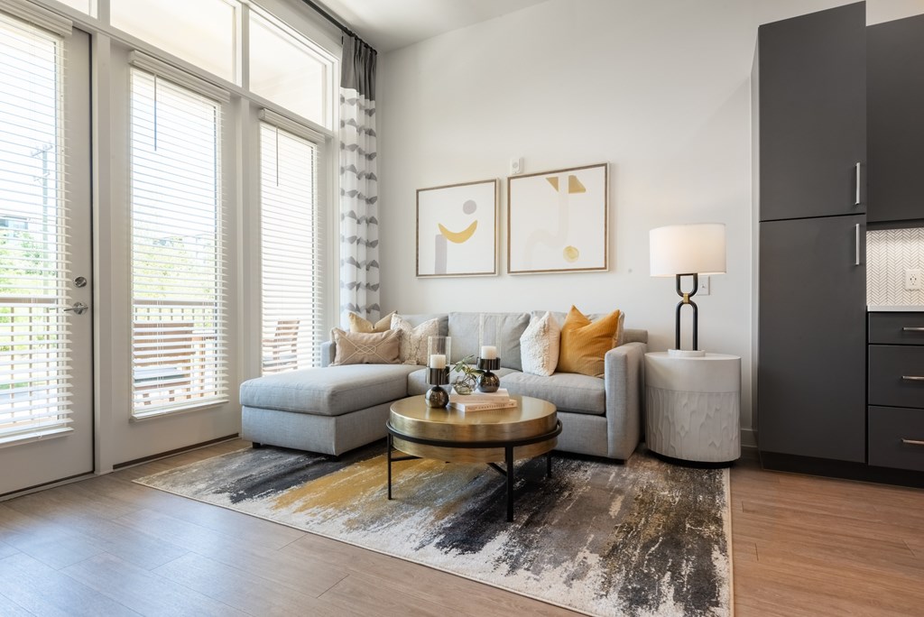 A living room with a grey couch, a coffee table, and a lamp.