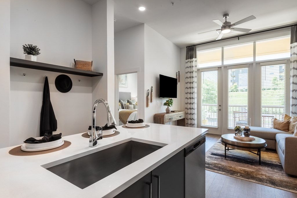 A modern kitchen with a large island and a dining area with a view.