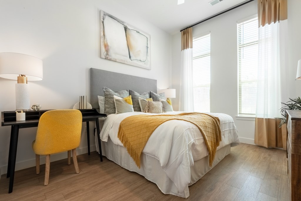 A bedroom with a bed, desk, and chair.