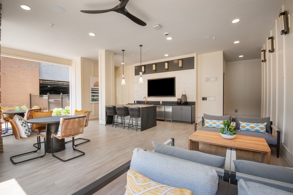 A modern living room with a kitchen area in the background.