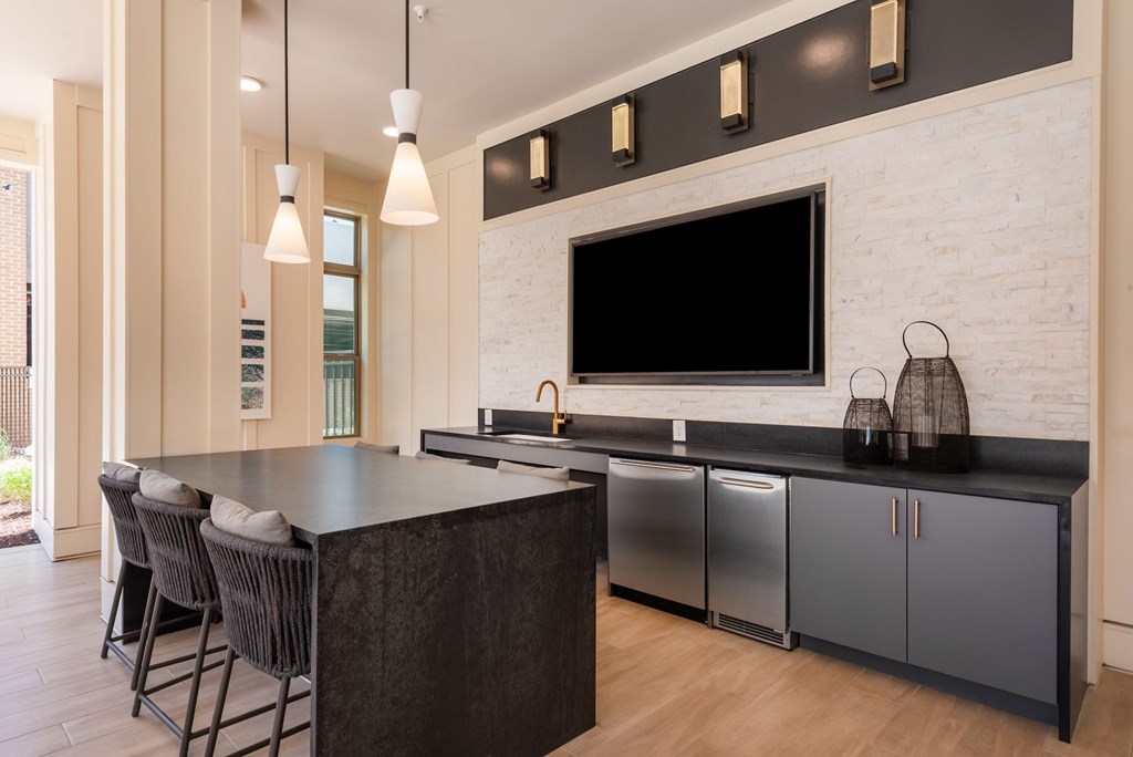 A modern kitchen with a black countertop and stainless steel appliances.