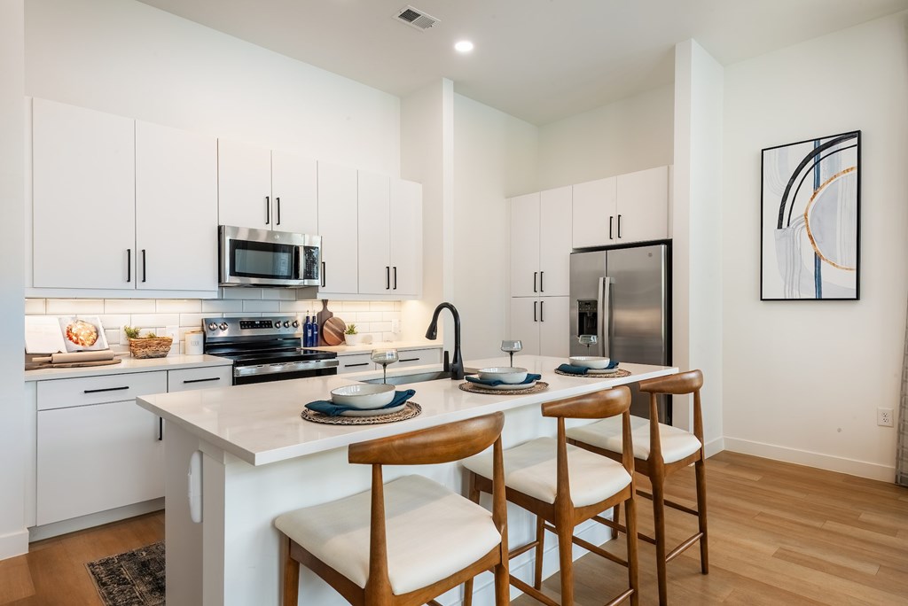 A modern kitchen with white cabinets and a white countertop.