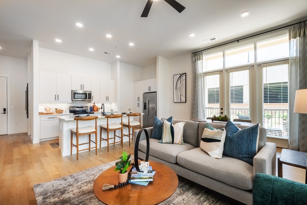 A modern living room with a grey couch and a wooden coffee table.