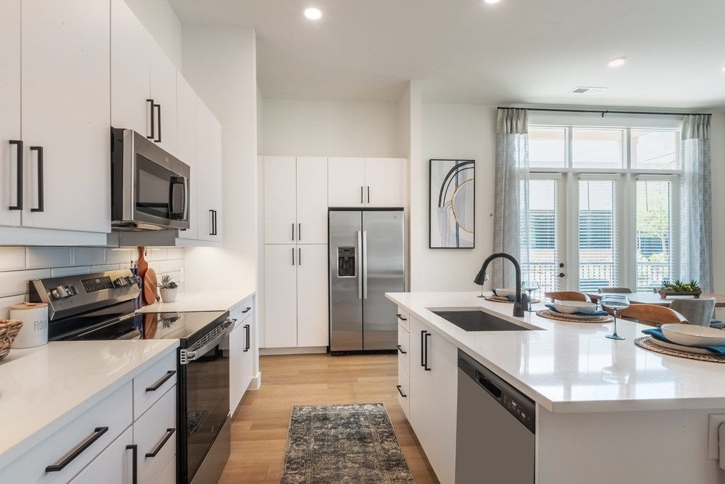 A modern kitchen with white cabinets and a central island.