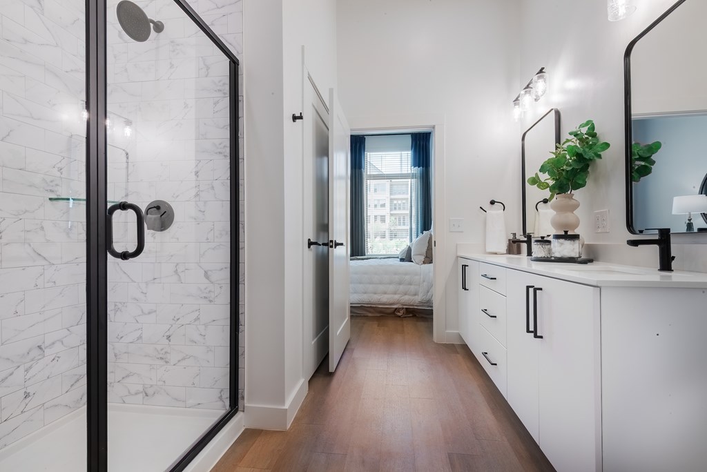 A bathroom with a marble wall and a wooden floor.