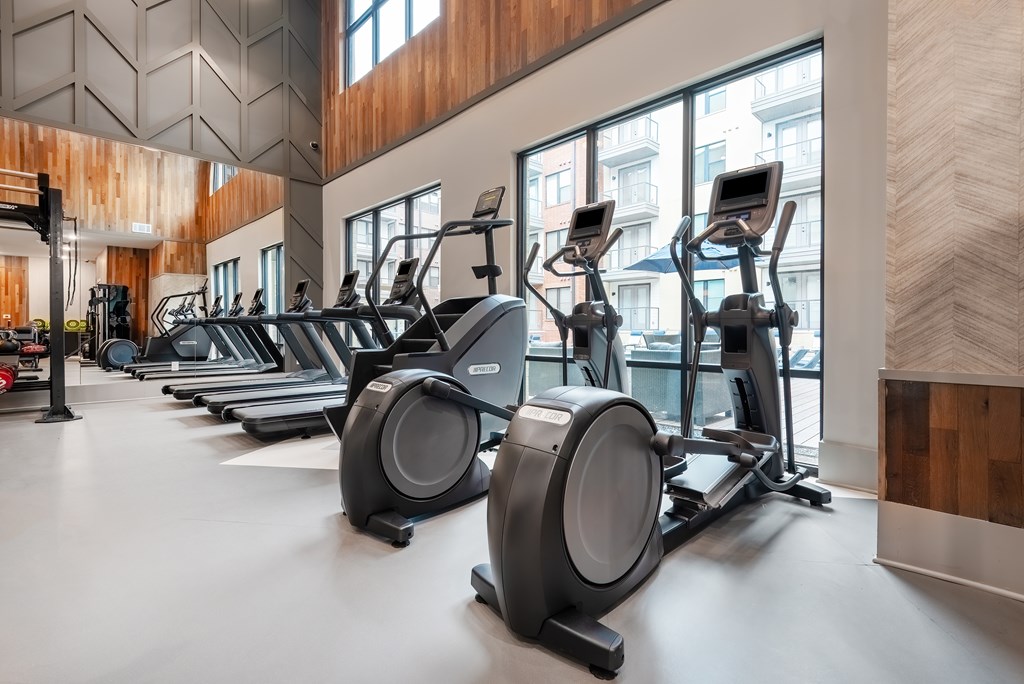 A Gym With Treadmills, A Stair Climber, And Elipticals