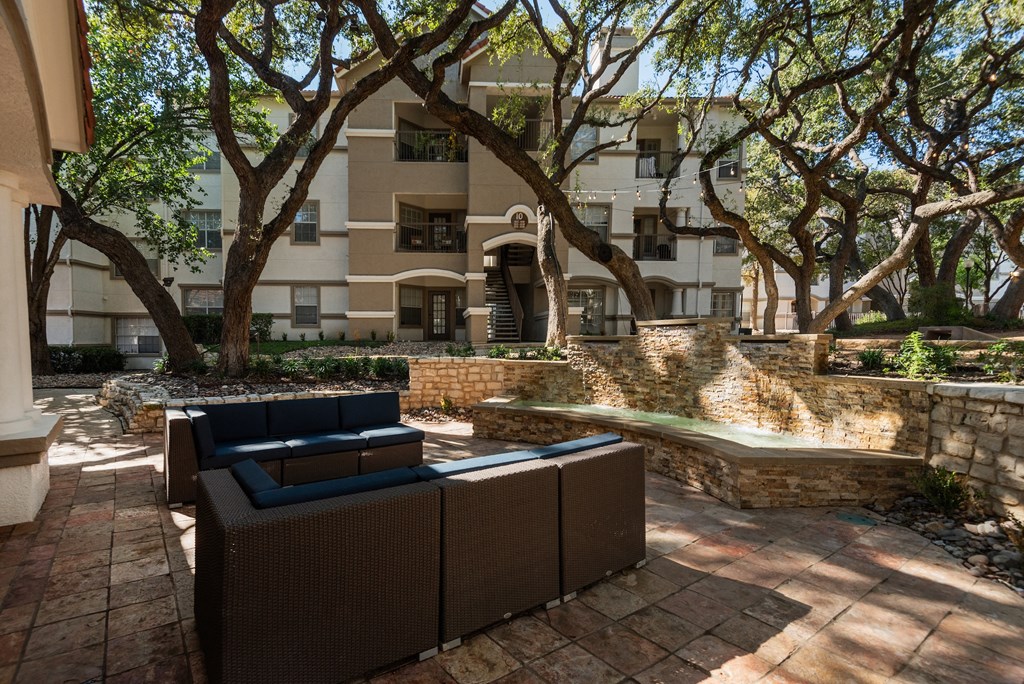 a courtyard with furniture and a fountain in front of an apartment building  at Hayden on West Ave, San Antonio