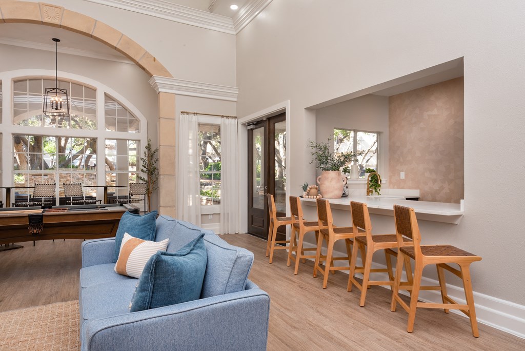 a living room with a blue couch and a table with chairs  at Hayden on West Ave, San Antonio