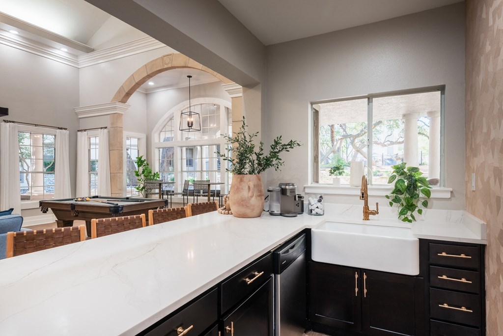 an open kitchen with a large white counter top and a pool table  at Hayden on West Ave, San Antonio