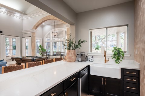 an open kitchen with a large white counter top and a pool table