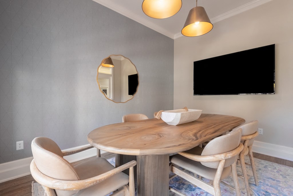 a dining area with a wooden table and chairs and a tv on the wall  at Hayden on West Ave, Texas
