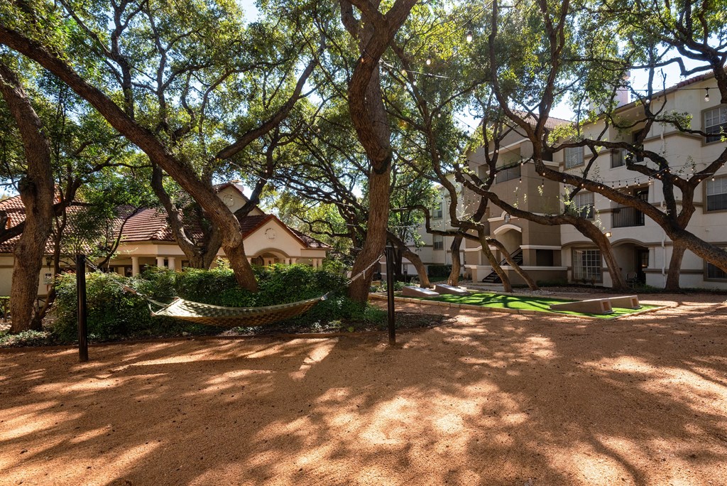 a hammock in the shade of trees in front of a building  at Hayden on West Ave, San Antonio, TX, 78216