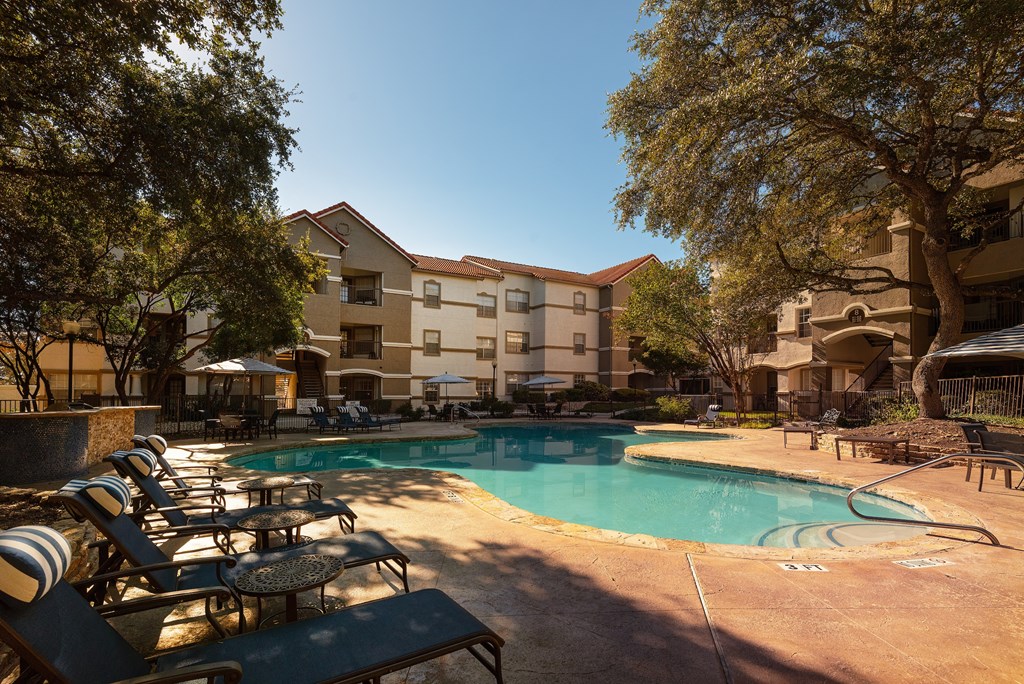 a swimming pool with chairs and a building in the background  at Hayden on West Ave, San Antonio