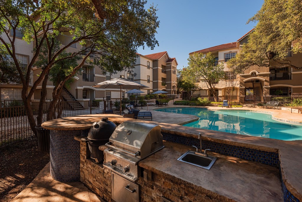 a backyard with a swimming pool and a barbecue grill  at Hayden on West Ave, San Antonio