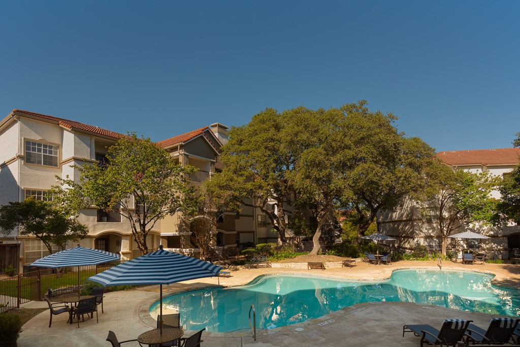 a swimming pool with umbrellas and a building in the background  at Hayden on West Ave, San Antonio, TX