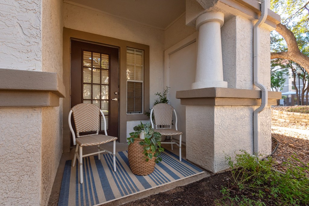 a front porch with two chairs and a potted plant  at Hayden on West Ave, San Antonio, Texas
