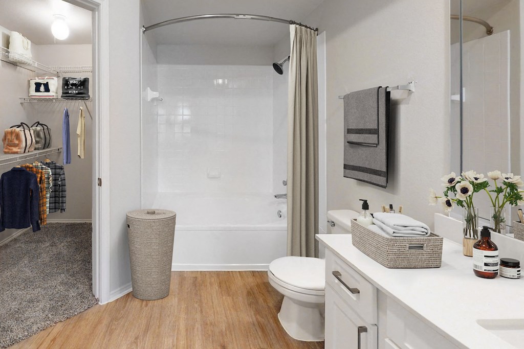 a bathroom with a white toilet next to a white bathtub with a shower curtain  at Hayden on West Ave, San Antonio